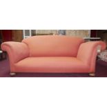 An early 20th century club sofa raised on bun feet and castors