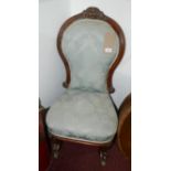 A Victorian mahogany nursing chair, with floral damask raised on cabriole legs and castors