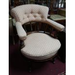 A Victorian aesthetic mahogany tub chair on castors