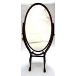 A 19th century mahogany oval cheval mirror, with boxwood inlay, raised on cabriole legs and castors,
