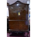 A mid 20th century burr walnut drinks cabinet with well fitted and mirrored interior, makers