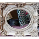 A cream ornate mirror with bevelled plate