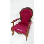 A Victorian rosewood spoon back armchair, with red floral damask button back upholstery, raised on