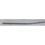 A boxed 18ct white gold diamond and tanzanite tennis bracelet composed of alternating stones to a
