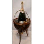 A brass wine cooler on mahogany stand with a large presentation bottle of champagne, (stand H.54 D.