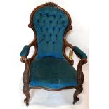 A Victorian mahogany spoon back armchair with blue velour button back upholstery, raised on cabriole