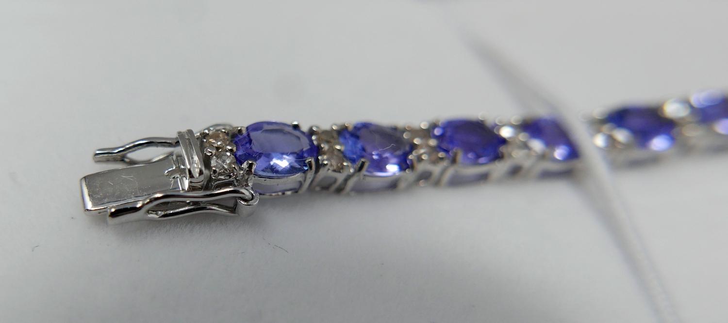 A boxed 18ct white gold diamond and tanzanite tennis bracelet composed of alternating stones to a - Bild 4 aus 5