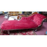 A Victorian mahogany chaise lounge with red velour button back upholstery, raised on turned legs,