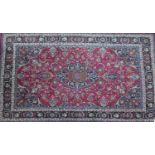 A North East Persian Meshad carpet, central floral medallion with repeating spandrels on a rouge