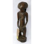 An African carved wooden figure of a woman with scarification to face and body, H.43cm