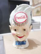 A collection of Coca-Cola memorabilia, to include a cast iron money bank in the form of young boy'