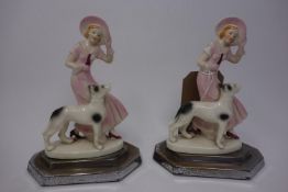 A pair of Art Deco porcelain figural studies of a young lady and her dog, on stepped silver plated