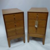 An early 20th century pair of solid oak pedestal chests, with three drawers, raised on tapered legs,