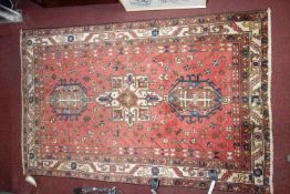 A North West Persian Heriz rug, triple pole medallion with repeating petal motifs on a terracotta