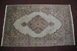 A 20th century part silk Hereke rug, with floral medallion on a cream ground, contained by floral