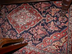 A fine Sarouk rug, with central floral medallion, on a red and blue ground, contained by floral