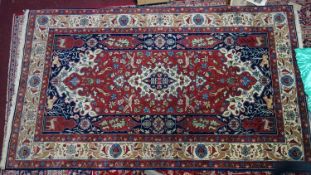 A zoomorphic Tabriz carpet, with central floral medallion, on a red and blue ground, contained by