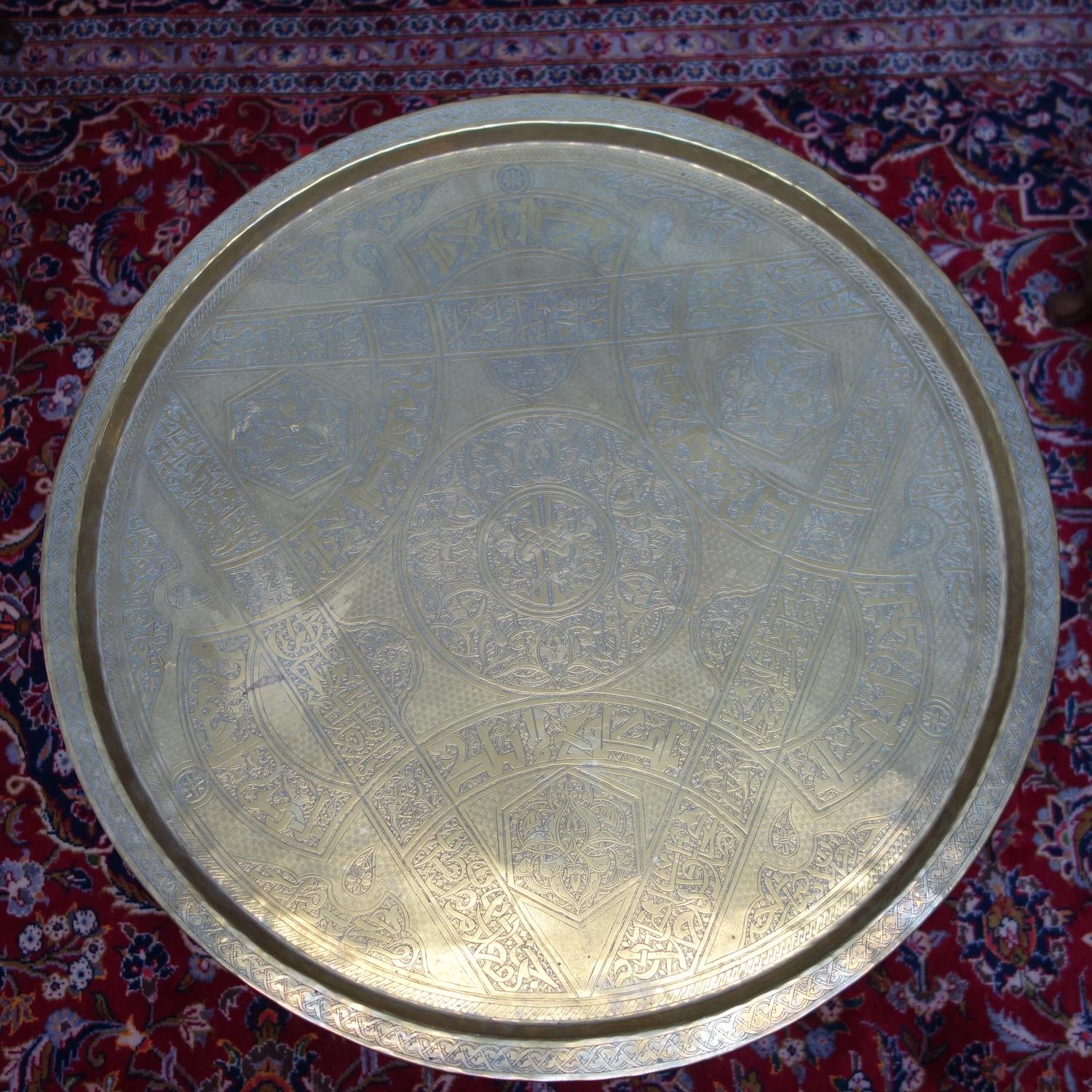 An Islamic brass tray on folding hardwood stand, the tray engraved with scrolling foliage, geometric - Image 2 of 2