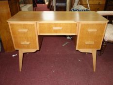 A mid 20th century light oak desk, with five drawers, raised on splayed tapered legs, H.75 W.110 D.