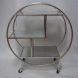 An Art Deco style drinks trolley of circular design, with three bevelled mirrored tiers, raised on