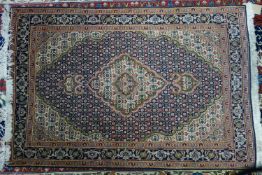 A part silk Tabriz rug, with floral medallion, on a blue and beige ground, contained by floral