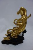 A carved gilt painted figure of Guanyin, standing on a stylised cloud base with gilt rabbit, H.33cm