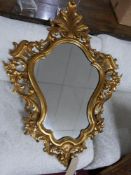 A Rococo style gilt framed carved wood floral wall mirror. H.102 W.75cm