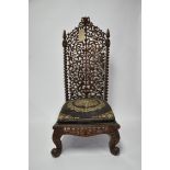 An Indonesian carved teak high backed chair