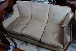 An Art Deco cream leather and walnut sofa