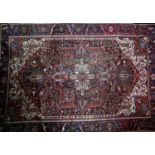 An antique Heriz carpet, with central geometric medallion, on a red, blue and cream ground,