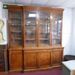A William IV burr elm breakfront library bookcase, the inverted stepped pediment above four glazed