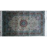 A 20th century fine silk Turkish Hereke rug, with central floral medallion, on a green ground,