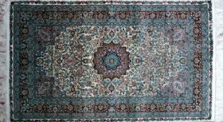 A 20th century fine silk Turkish Hereke rug, with central floral medallion, on a green ground,