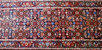 A North West Persian Farahan runner, repeating stylised petal motifs on a sapphire field