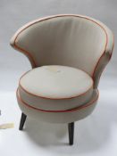 A wing back tub chair, grey upholstery with orange piping, on splayed legs