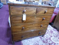 An early 19th century mahogany chest, two short over three long drawers, with ebony inlay, raised on