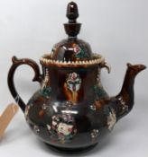 A large brown glazed teapot, polychrome decorated with flowers, H.38cm