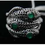 A sterling silver 3-snake ring, set with 3 round faceted emeralds within a textured coiled