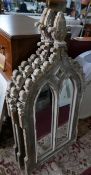 Three Gothic style garden mirrors, distressed painted, with floral finial above twin arched glass