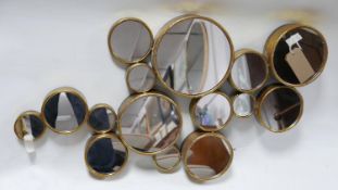 A contemporary gilt metal bubble mirror, with 15 circular mirrors of varying size, 106 x 60cm