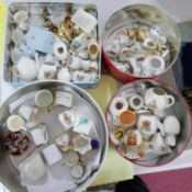 A collection of miniature porcelain in three tin boxes