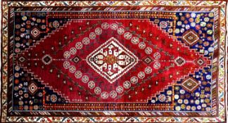 A South West Persian Qashgai carpet, central diamond medallion with repeating petal motifs on a