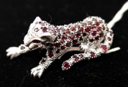 A large sterling silver leopard brooch pave-set with garnets (in the Cartier style), 5.5 x 2 x