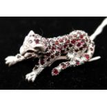 A large sterling silver leopard brooch pave-set with garnets (in the Cartier style), 5.5 x 2 x