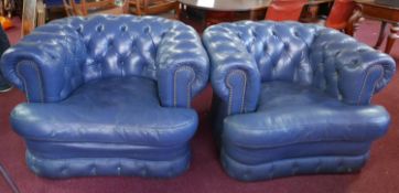 A pair of blue leather Chesterfield armchairs