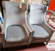 A pair of grey velour wing back armchairs, on square tapered legs