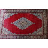 A large Tabriz carpet with central floral medallion, on a red ground, contained by geometric