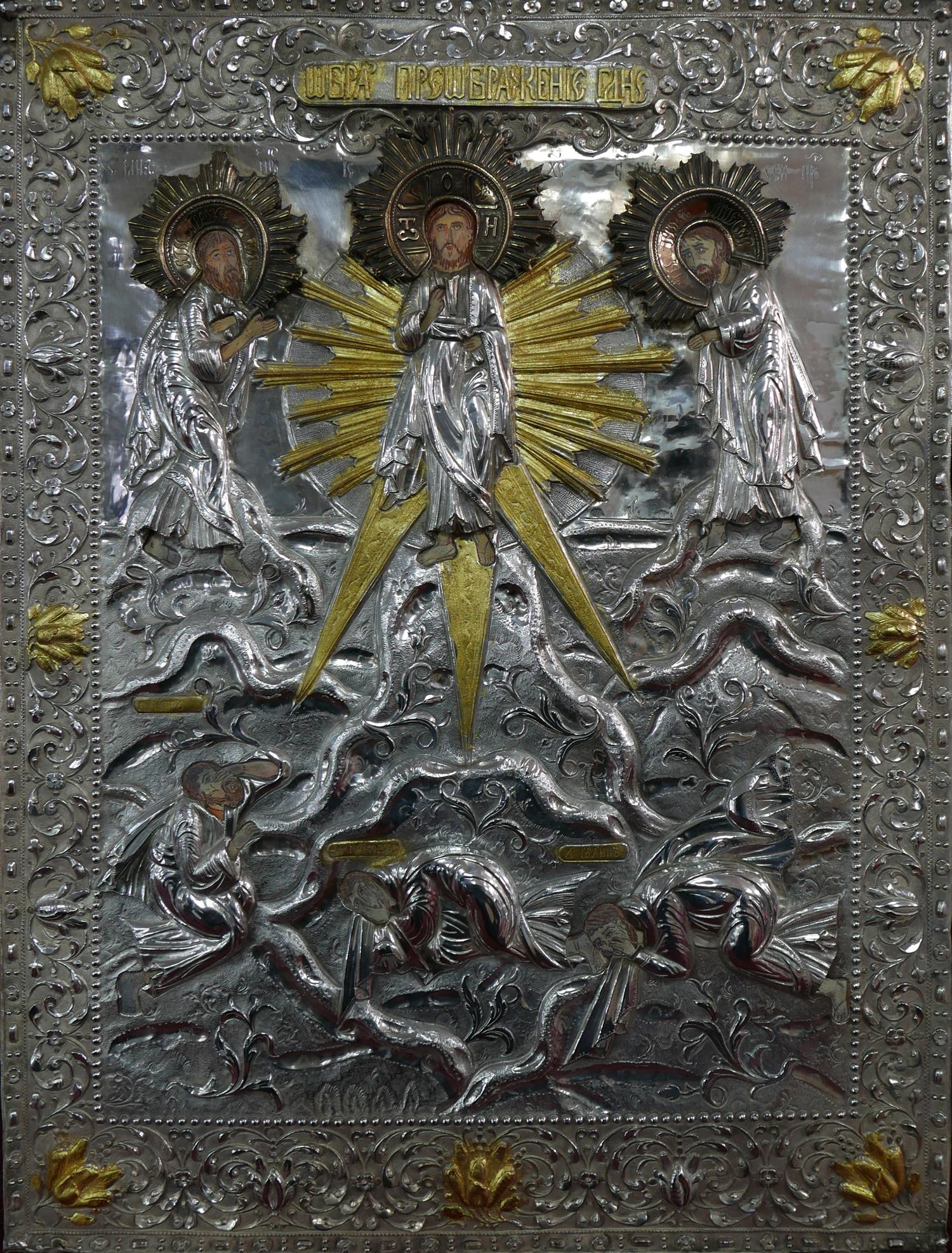 A Russian white metal icon, the oklad depicting Jesus flanked by two saints, parcel gilded and