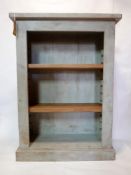 An Indigo distressed painted bookcase with adjustable shelves, raised on stepped base, H.127 W.92