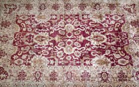 A large Afghan Chubi carpet, with stylized floral design on a rouge and beige ground, bought from